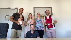 Photo de groupe prise lors d’une session de formation SST. Les participants, souriants et engagés, posent avec le matériel pédagogique utilisé pour les exercices pratiques, symbolisant l’esprit d’équipe et l’importance de la formation en secourisme au travail.