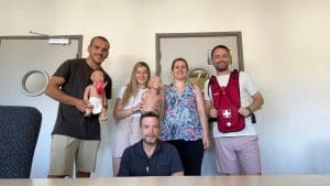 Photo de groupe prise lors d’une session de formation SST. Les participants, souriants et engagés, posent avec le matériel pédagogique utilisé pour les exercices pratiques, symbolisant l’esprit d’équipe et l’importance de la formation en secourisme au travail.