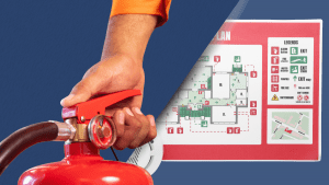 Main tenant un extincteur au premier plan avec un plan d’intervention incendie d’ERP affiché en arrière-plan, montrant les accès, issues de secours et équipements de sécurité.